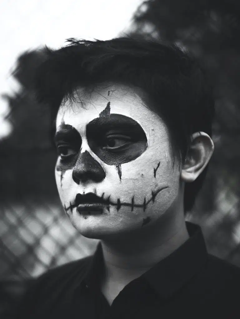 man in black suit jacket with face paint