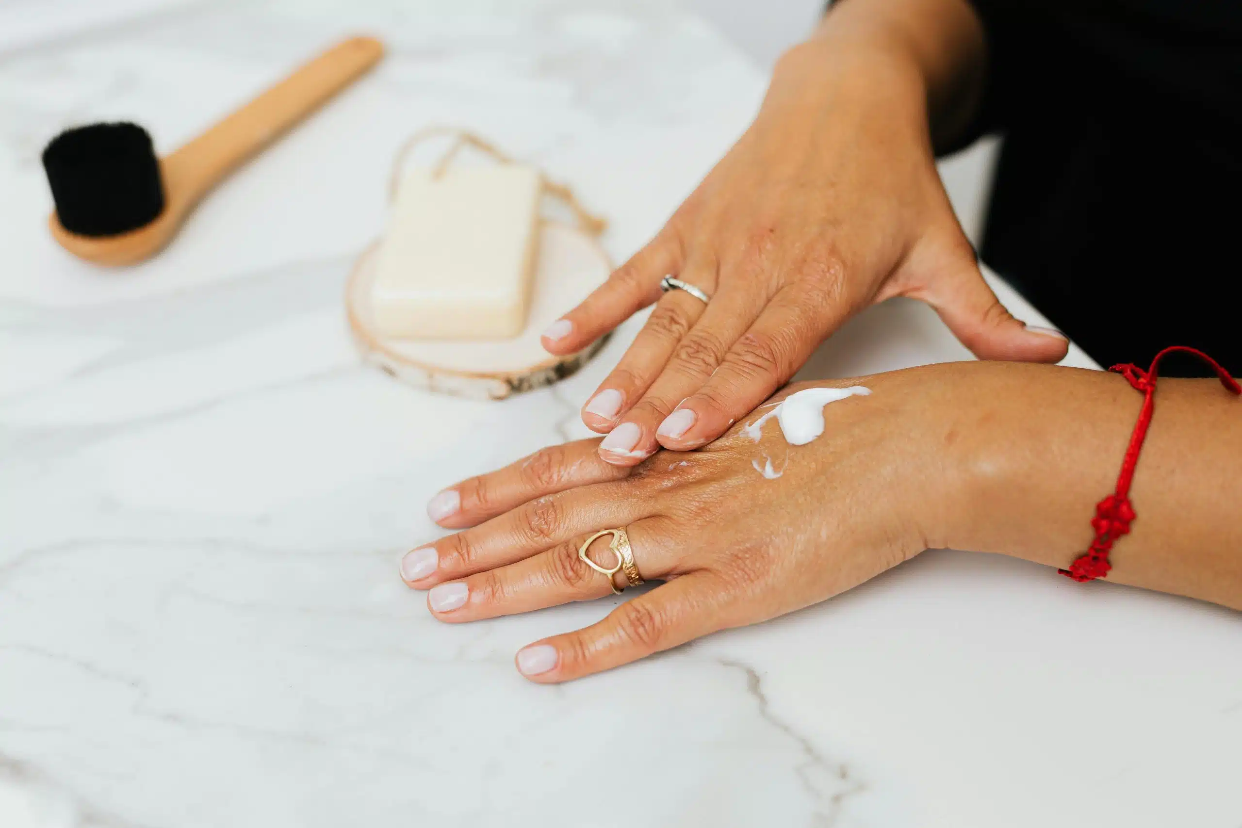 une femme appliquant de la crème sur ses mains